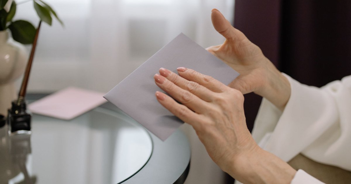 Mãos segurando um envelope — o momento de receber a citação de uma ação monitória do banco