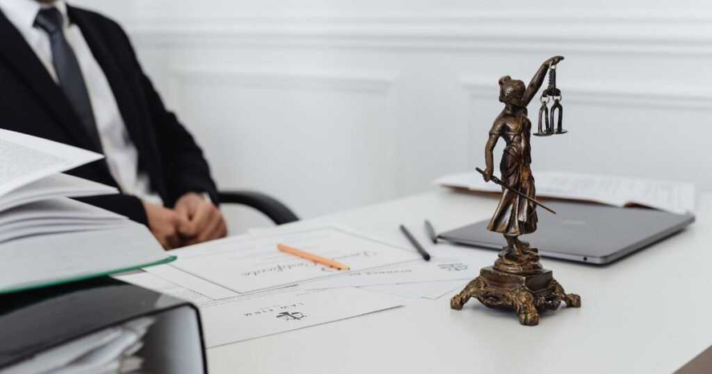 Mesa de advogado com a estátua da Justiça e documentos — a defesa técnica contra a execução bancária