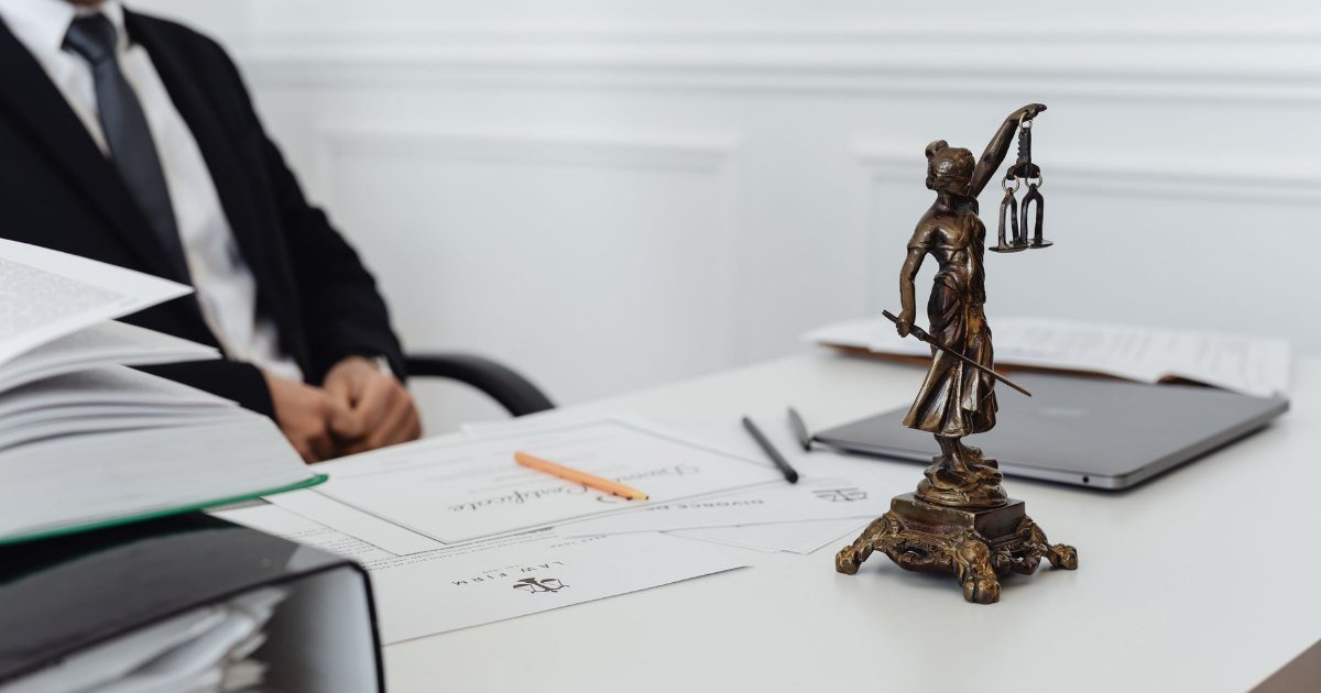 Mesa de advogado com a estátua da Justiça e documentos — a defesa técnica contra a execução bancária